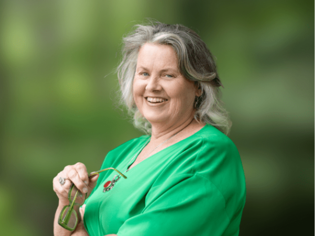 a woman, jannine barron, looks at the camera and smiles