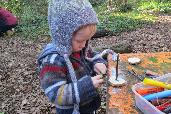 a small child plays with crafts outdoors